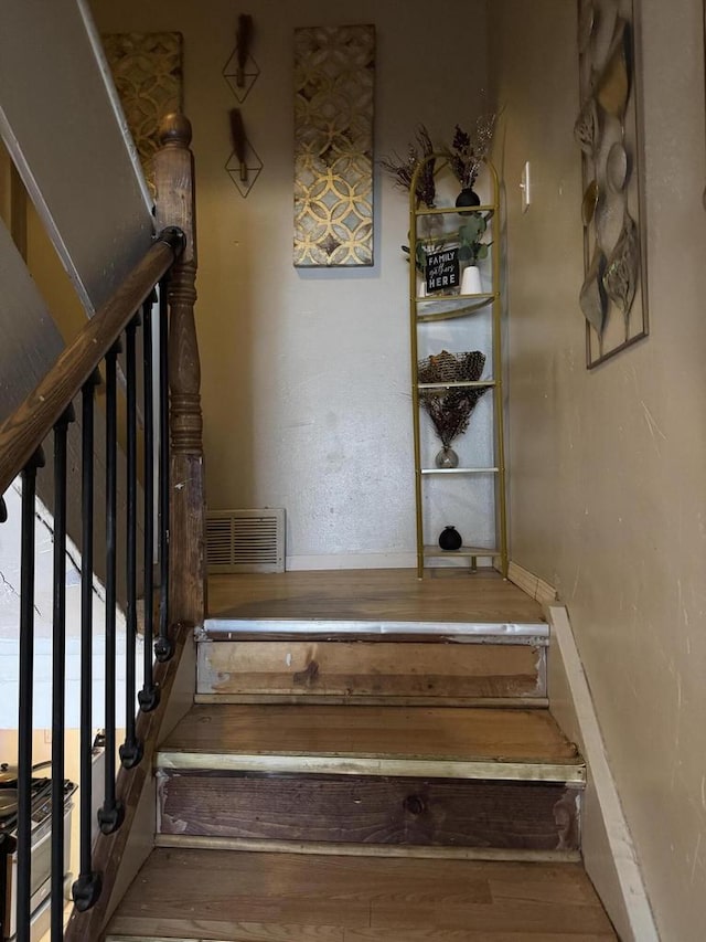 staircase with wood finished floors and visible vents