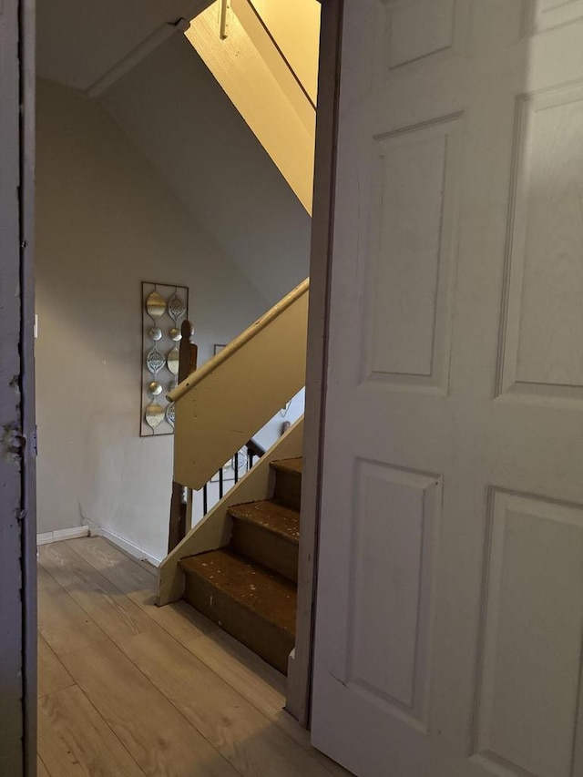 stairway featuring wood finished floors and baseboards