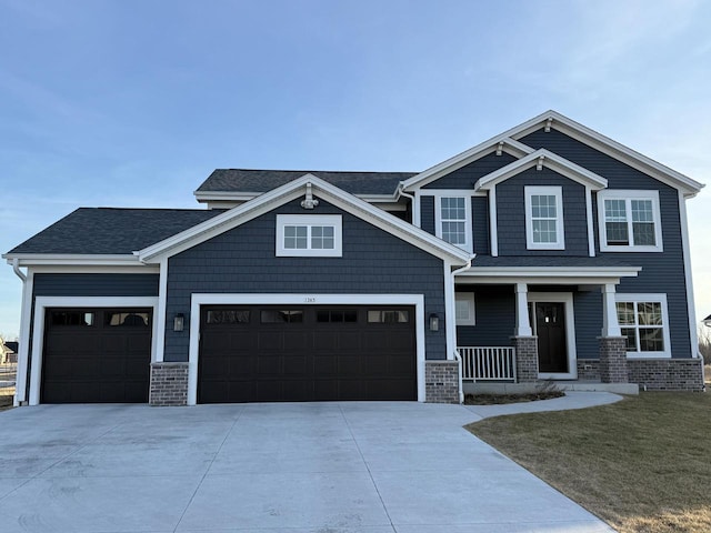 craftsman-style home with covered porch, concrete driveway, a front yard, a shingled roof, and a garage