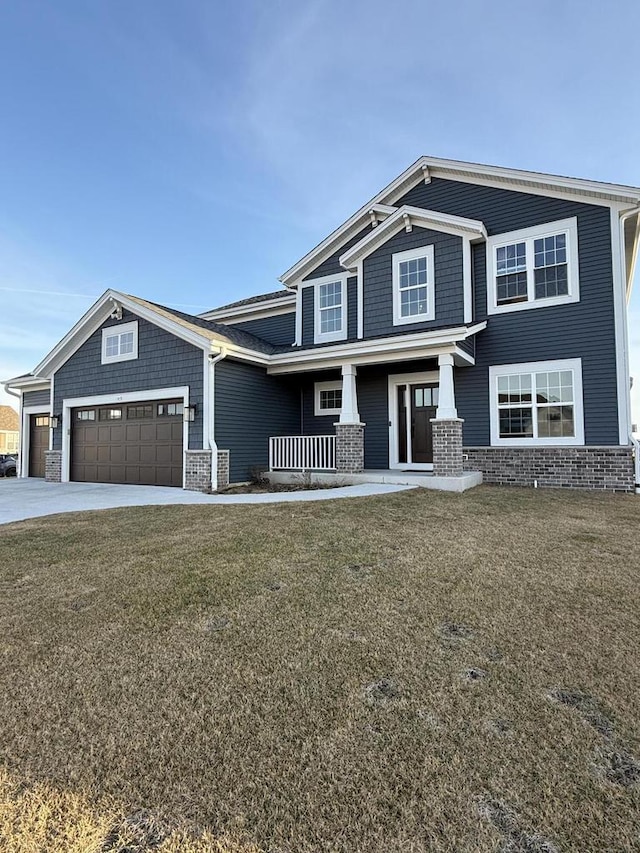 craftsman-style home with a front lawn, covered porch, a garage, and driveway