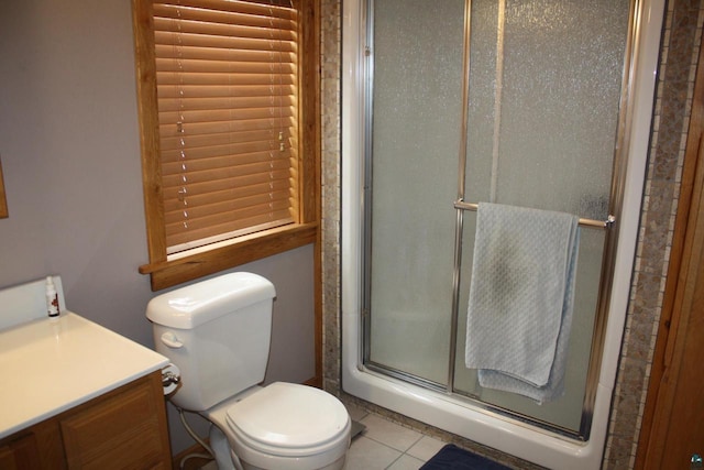 full bath with toilet, a stall shower, vanity, and tile patterned flooring