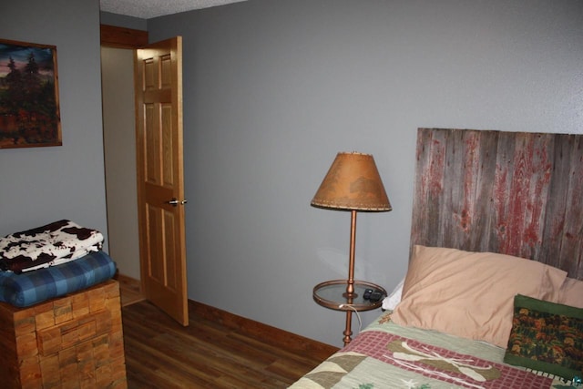 bedroom with a textured ceiling and wood finished floors