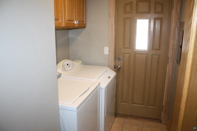 washroom featuring light tile patterned floors, cabinet space, and separate washer and dryer