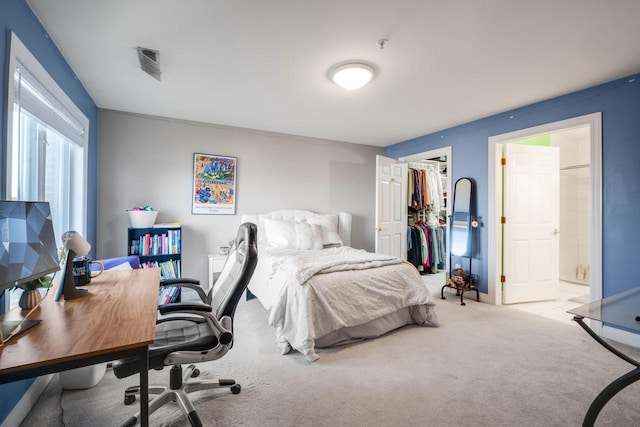 bedroom featuring ensuite bath, a closet, and carpet floors