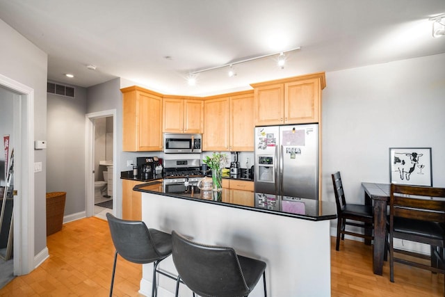 kitchen with light wood-style floors, light brown cabinets, visible vents, and appliances with stainless steel finishes