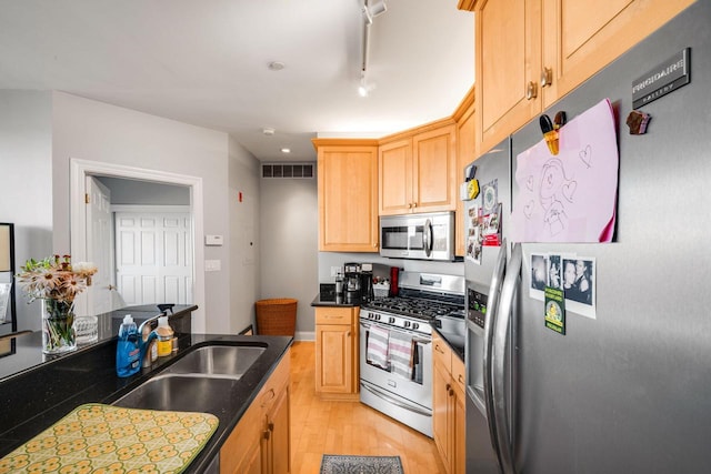 kitchen featuring light wood-type flooring, visible vents, light brown cabinets, dark countertops, and stainless steel appliances