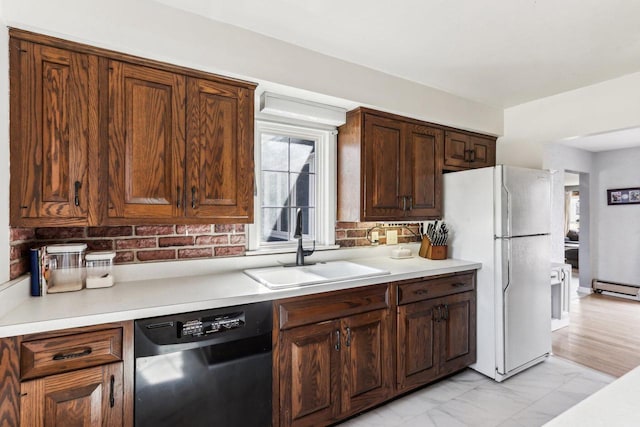 kitchen with dishwashing machine, freestanding refrigerator, a sink, light countertops, and marble finish floor