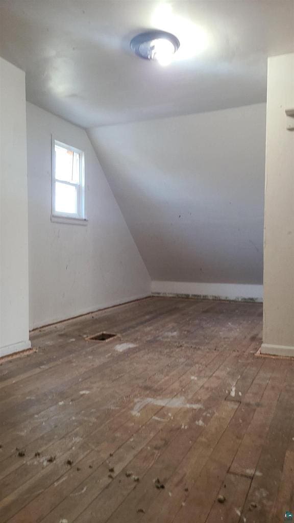 bonus room featuring hardwood / wood-style floors, vaulted ceiling, and visible vents