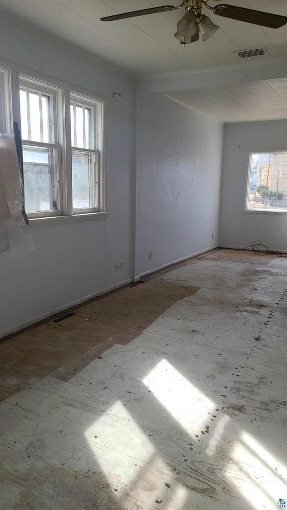 unfurnished room featuring visible vents and ceiling fan