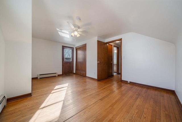 interior space featuring baseboard heating, light wood-type flooring, and baseboards