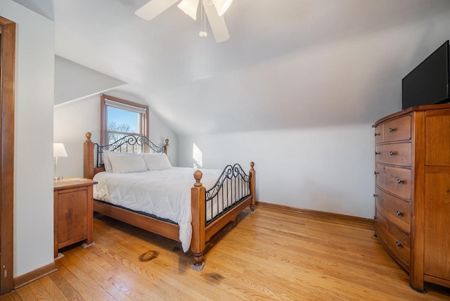 bedroom with baseboards, lofted ceiling, light wood-style flooring, and a ceiling fan