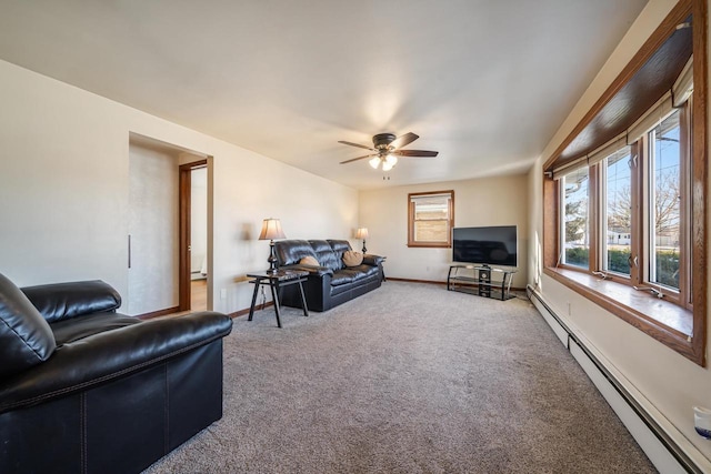 living area with baseboard heating, carpet flooring, a ceiling fan, and baseboards