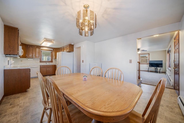 dining area featuring a baseboard radiator and ceiling fan with notable chandelier