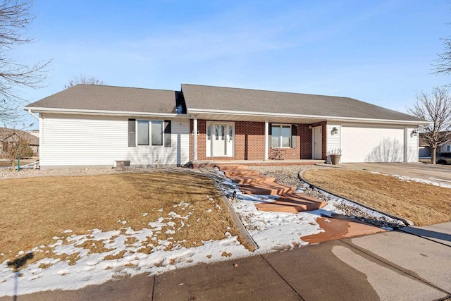 ranch-style home featuring brick siding, driveway, and an attached garage