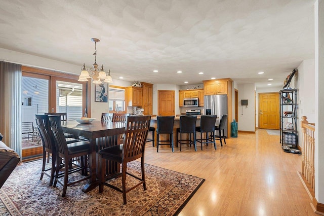 dining room featuring a chandelier, recessed lighting, light wood-style flooring, and a textured ceiling