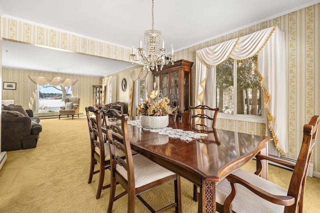 dining room featuring carpet, a chandelier, ornamental molding, and wallpapered walls