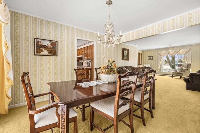 dining space featuring baseboards, light carpet, a chandelier, and wallpapered walls