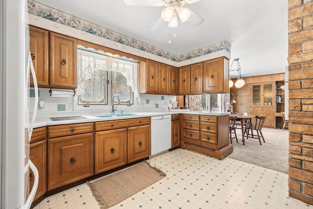 kitchen featuring brown cabinetry, light floors, fridge, and white dishwasher