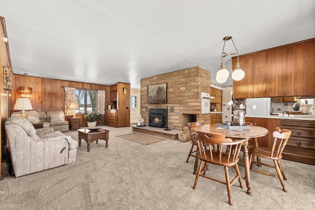 living area with wooden walls and light carpet