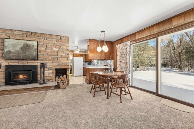 dining space featuring light colored carpet and a lit fireplace