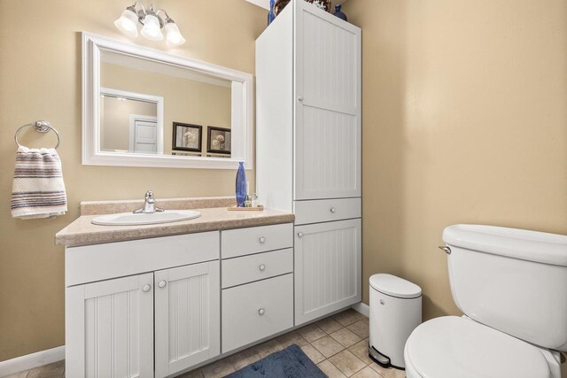 bathroom featuring toilet, vanity, and tile patterned flooring