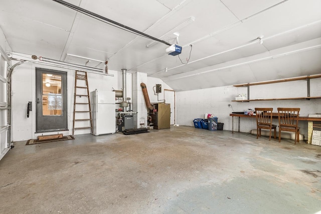 garage featuring a garage door opener and freestanding refrigerator