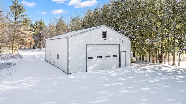 snow covered garage with a detached garage