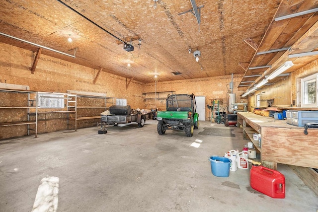 garage with gas water heater, a workshop area, and a garage door opener