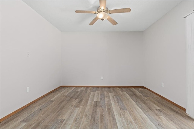 spare room with baseboards, light wood-style floors, and ceiling fan