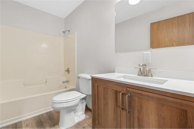 full bathroom with shower / washtub combination, toilet, vanity, and wood finished floors