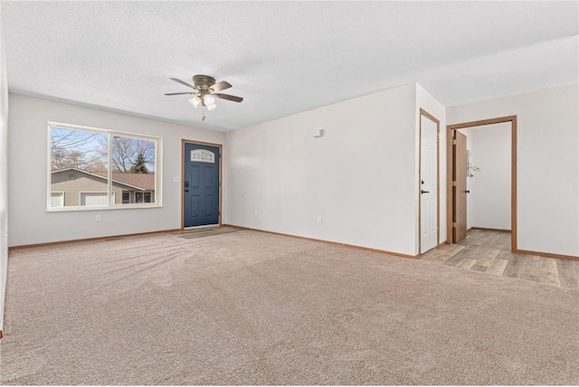 spare room with baseboards, carpet flooring, a textured ceiling, and ceiling fan