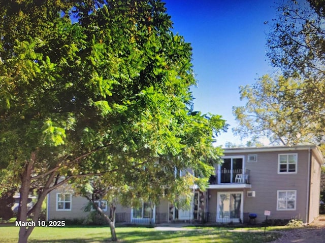 view of front of house with a balcony and a front lawn