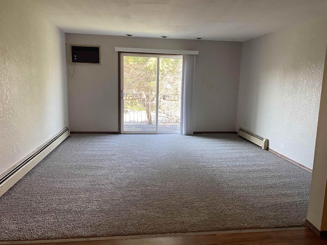 empty room featuring a wall mounted air conditioner, carpet floors, baseboard heating, and a textured wall