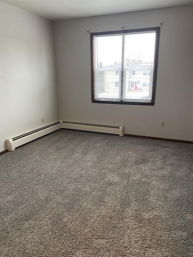 empty room featuring a baseboard heating unit, baseboards, and carpet flooring