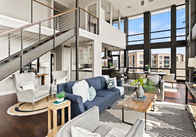 living area with a wall of windows, a high ceiling, and wood finished floors