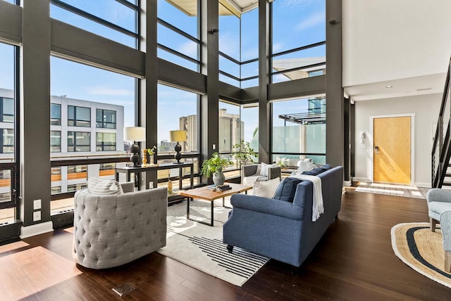 living area with floor to ceiling windows, baseboards, and wood finished floors