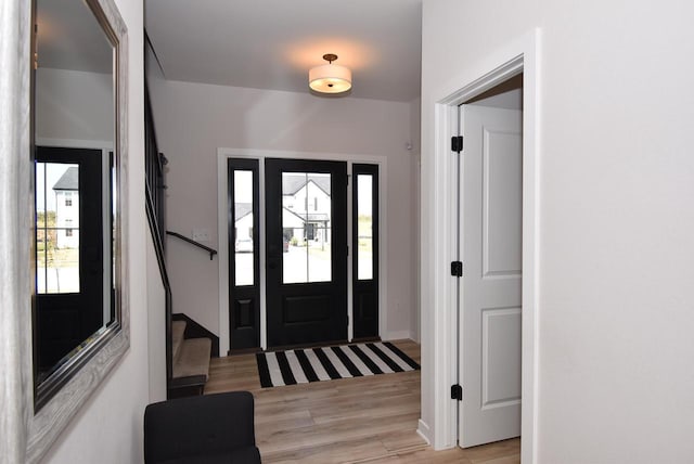 entryway with stairway and light wood-style flooring