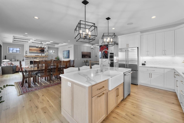 kitchen featuring a chandelier, open floor plan, stainless steel appliances, and a sink