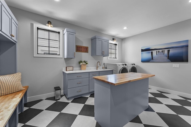 kitchen with tile patterned floors, washer and clothes dryer, gray cabinets, and butcher block counters