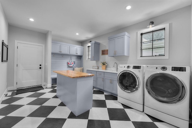 laundry room with recessed lighting, separate washer and dryer, light floors, and a sink