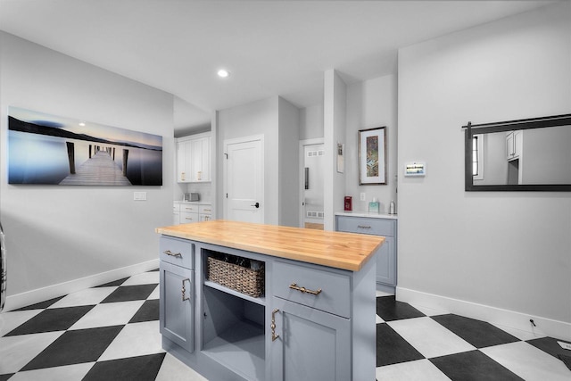 kitchen with recessed lighting, wooden counters, baseboards, and dark floors