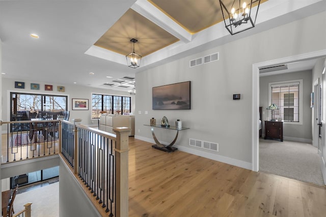 corridor featuring visible vents, an upstairs landing, and an inviting chandelier