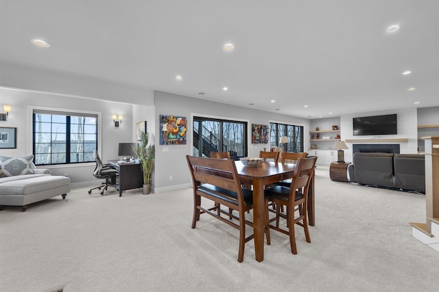 dining room featuring light carpet, recessed lighting, a fireplace, and baseboards