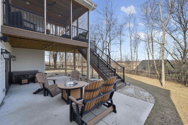 view of patio / terrace with stairway, a fire pit, a sunroom, and fence