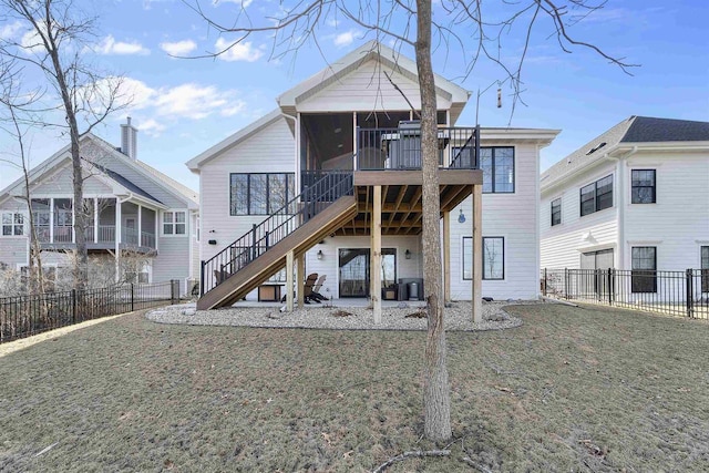 rear view of house with a yard, stairway, a fenced backyard, and a sunroom