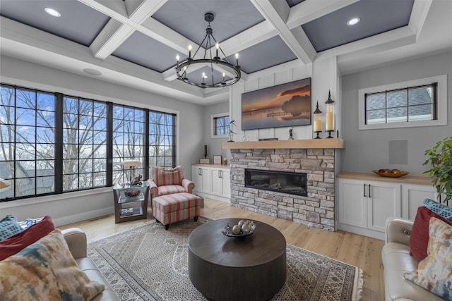 living area with coffered ceiling, an inviting chandelier, a fireplace, beamed ceiling, and light wood-type flooring