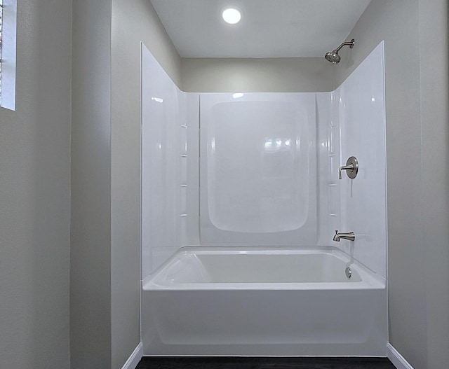 full bath with baseboards and shower / washtub combination