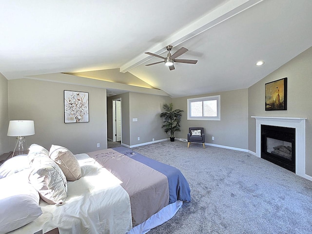 carpeted bedroom featuring a glass covered fireplace, lofted ceiling with beams, a ceiling fan, and baseboards