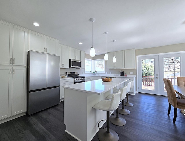 kitchen featuring dark wood-style floors, white cabinetry, stainless steel appliances, and light countertops