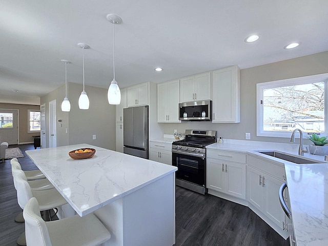 kitchen featuring a sink, light stone countertops, appliances with stainless steel finishes, and white cabinetry